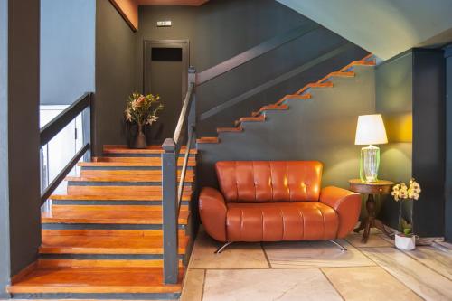 an orange chair sitting next to a staircase at Parnassos Delphi Hotel in Delfoi