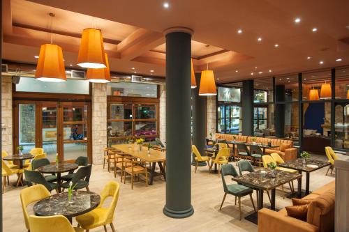 un restaurante con mesas, sillas y ventanas en Parnassos Delphi Hotel, en Delfos