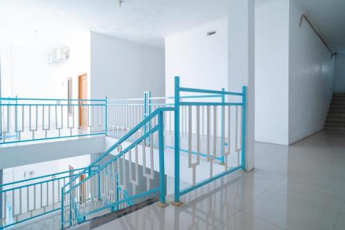 a stairway with blue railing in a building at RedDoorz near RS Mitra Keluarga Waru in Waru