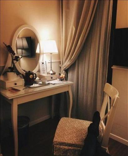 ローマにあるColfelice Roomsの鏡と椅子が置かれた机のある部屋