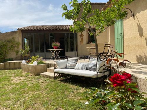 a white couch sitting in the backyard of a house at Les Chêneslierres in Lourmarin