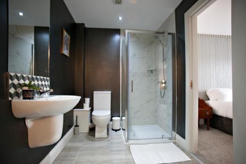 a bathroom with a toilet and a sink and a shower at Portcaman House in Bushmills
