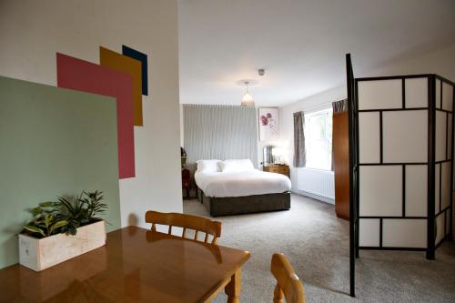a hotel room with a bed and a table and a dining room at Portcaman House in Bushmills