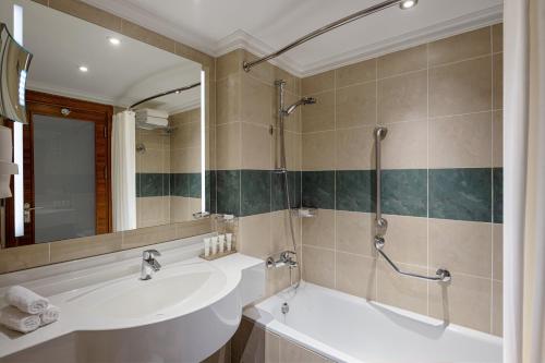 a bathroom with a sink and a tub and a mirror at Crowne Plaza Amman by IHG in Amman