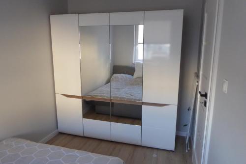 a white cabinet with a bed inside of it at Dziwnówek Słoneczne Tarasy Gray in Dziwnówek