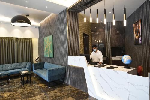 a man wearing a face mask in a hotel lobby at Kyriad Hotel Pimpri in Pune