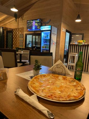 a large pizza sitting on top of a wooden table at Hotel Real in Ishull-Lezhë