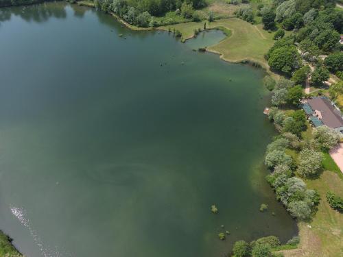 an overhead view of a lake with trees and a house at Aquasole in Mercallo