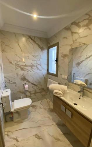 a bathroom with a sink and a toilet and a mirror at Sea View Private Terrace - Fibre Wi-Fi & Netflix in Essaouira