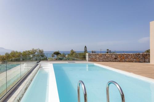a swimming pool with a view of the ocean at Aristotelis Residence in Petres