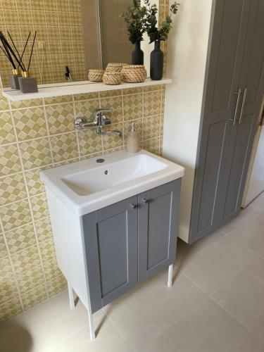 ein Badezimmer mit einem weißen Waschbecken und einem Spiegel in der Unterkunft Apartman Luš in Sutivan