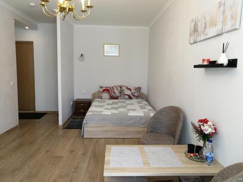 Un dormitorio con una cama y una mesa dentro. en Šiauliai City Apartment, en Šiauliai