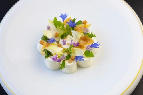 a white dessert with flowers on a white plate at Fleur de Loire in Blois