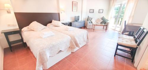 una habitación de hotel con 2 camas y una silla en Skol 329 – Spacious Beachfront Studio with Sea Views, en Marbella