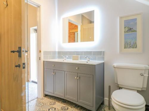 a bathroom with a toilet and a sink and a mirror at Acorn Lodge in Stafford