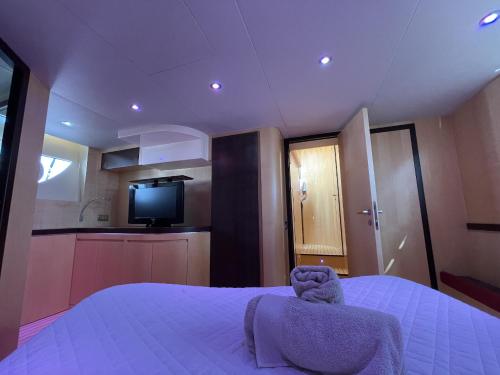 a bedroom with a bed and a tv and a kitchen at Yacht Lakura 55 in Naples