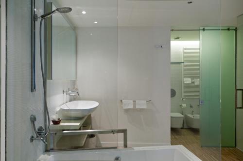 a bathroom with a sink and a bath tub at Hotel La Conchiglia in Fregene