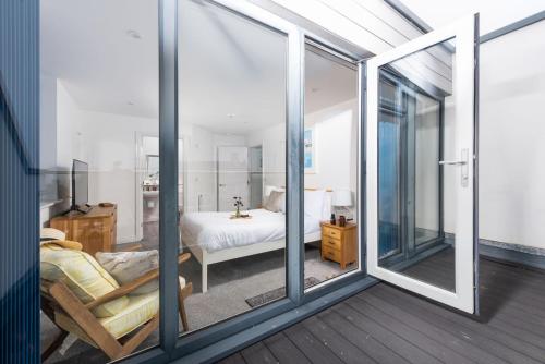 Kingsley House, Newquay في نيوكواي: غرفة بأبواب زجاجية منزلقة تؤدي إلى غرفة نوم