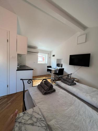 a living room with two beds and a kitchen at Casa David in Piran