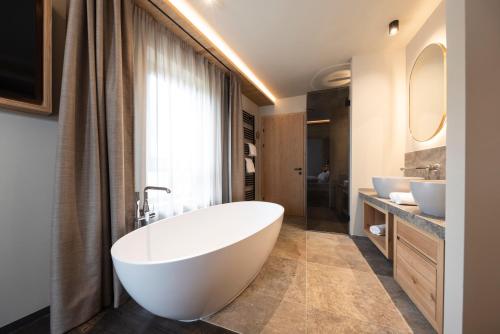 a bathroom with two sinks and a large tub at Santre dolomythic home in Bressanone