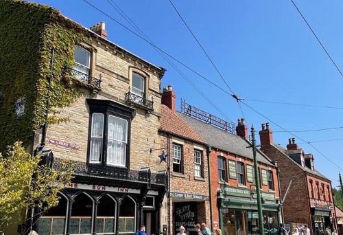 a building on a street with people walking in front of it at Riding Farm Cottages in Gateshead