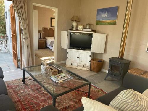 een woonkamer met een tv en een salontafel bij Lakeside Cottage on Spring Grove in Nottingham Road