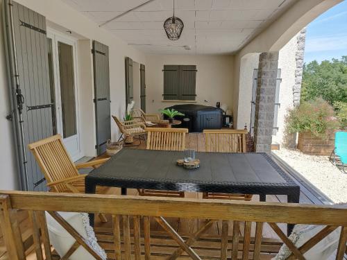 a patio with a black table and chairs at Le gîte de Marguerite in Chauzon