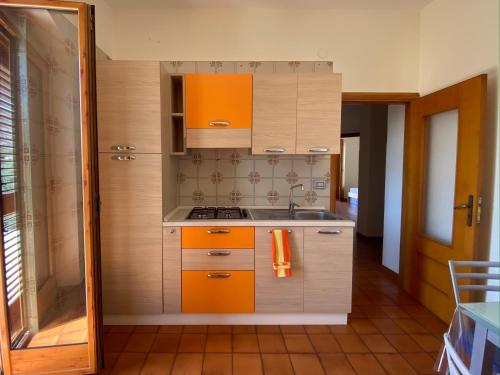 a small kitchen with orange cabinets and a sink at Casa Uliveto in Mattinata
