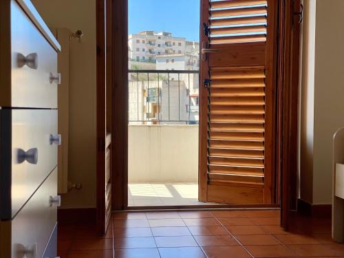 an open door to a balcony with a view of a building at Casa Uliveto in Mattinata