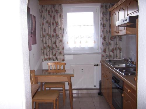 una piccola cucina con tavolo e finestra di Apartment Ilmtal Jena a Bad Berka