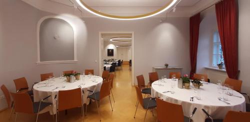 a dining room with white tables and chairs at Schloss Gumpoldskirchen in Gumpoldskirchen