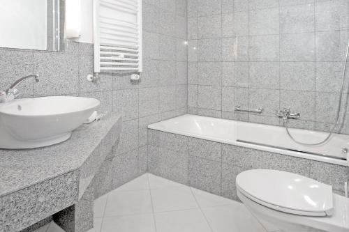 
a bathroom with a sink, toilet and bathtub at Hotel Astoria Bonn in Bonn
