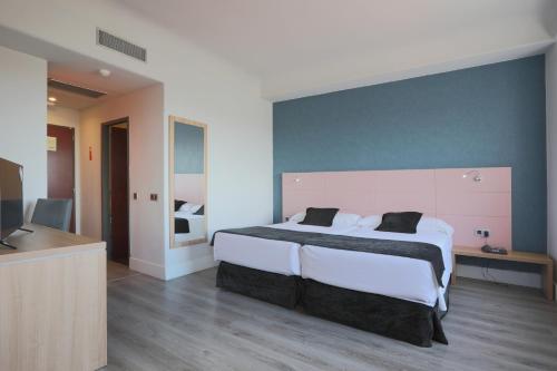 a bedroom with a large bed and a television at Hotel Chamartin The One in Madrid