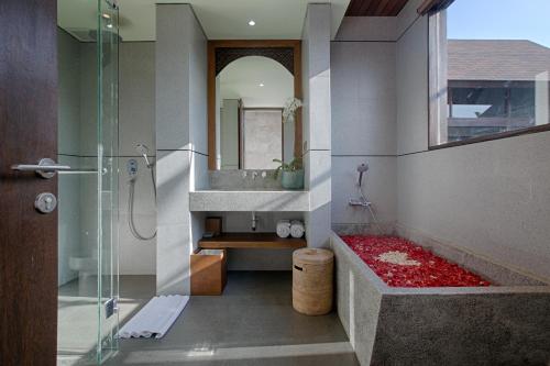 a bathroom with a shower and a sink and a tub at Taman Dharmawangsa Suites in Nusa Dua