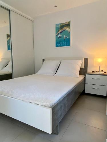 une chambre avec un grand lit et une table de chevet dans l'établissement Les locations Cinaureva « La Tourrisse », à La Crau