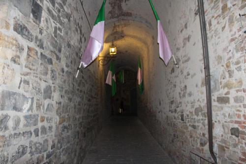 an alley way with flags hanging from a brick wall at Le Terrazze Del Chianti b&b Residenza d'Epoca e di Charme in Tavarnelle in Val di Pesa