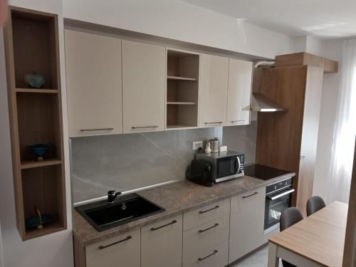 cocina con armarios blancos y microondas en Apartament Gabriella's Home, en Oradea