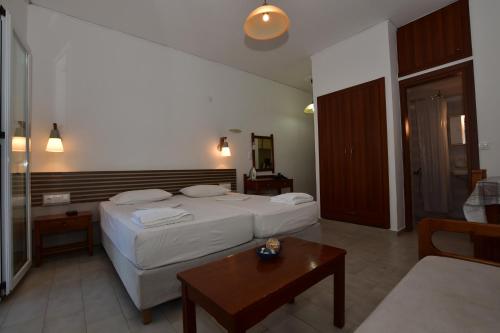 a hotel room with a bed and a coffee table at Morpheas Rooms in Palaiochóra