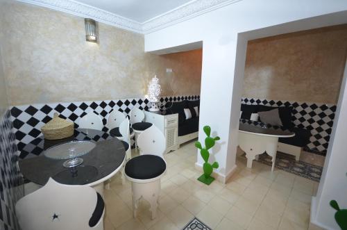 a room with a table and chairs and a sink at Maison de vacances avec vue mer in Essaouira