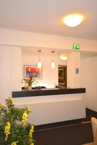 an office lobby with a reception counter and flowers at Hotel Kehrenkamp in Hagen