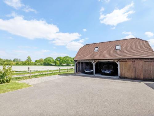 a barn with two cars parked inside of it at Carthagena, Birdham in Chichester