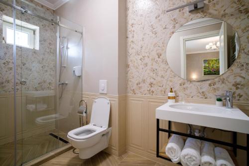 a bathroom with a toilet and a sink and a shower at Pensiunea Casa Sturza in Bacău