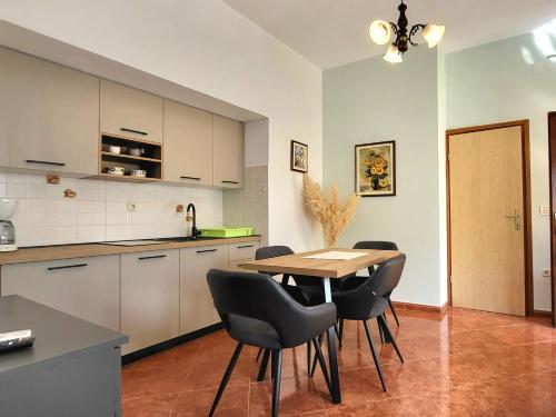 a kitchen and dining room with a table and chairs at Comfort Apartment Smokva in Vrsar