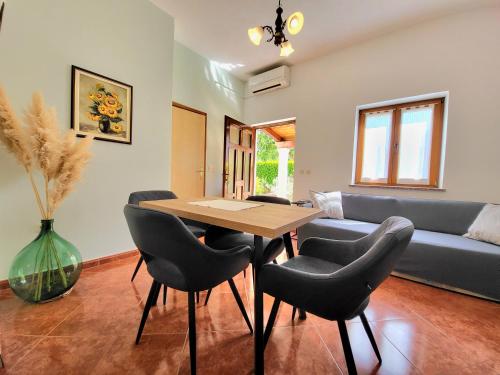a living room with a table and chairs and a couch at Comfort Apartment Smokva in Vrsar