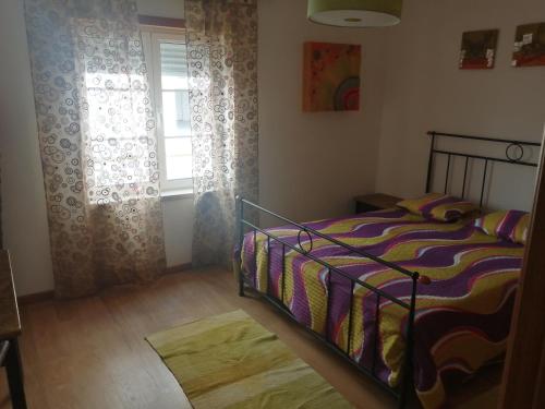 a bedroom with a bed and a window at Casa Campos in Nazaré