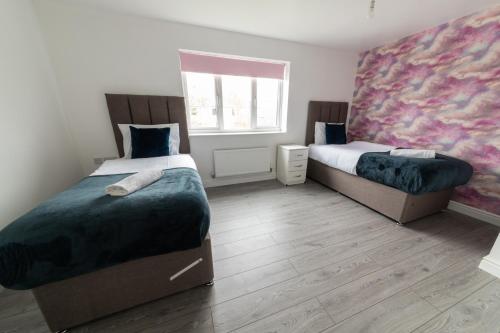 a bedroom with two beds and a window at Contractor-Ready House - Bright, Spacious, and Free WiFi Included! in Luton