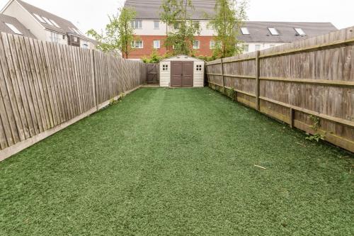 a backyard with a fence and a shed at Contractor-Ready House - Bright, Spacious, and Free WiFi Included! in Luton