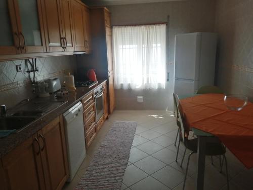 a kitchen with a wooden table and a kitchen with a dining table at Casa Campos in Nazaré