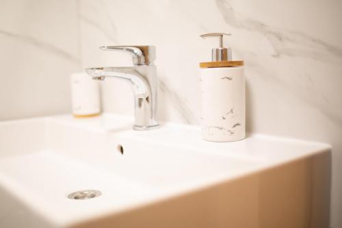 a bathroom sink with a soap dispenser on it at Apartman Kolura Vis in Vis