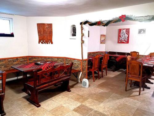 ein Esszimmer mit Holztischen und -stühlen in der Unterkunft Guest House Plamena in Krapets